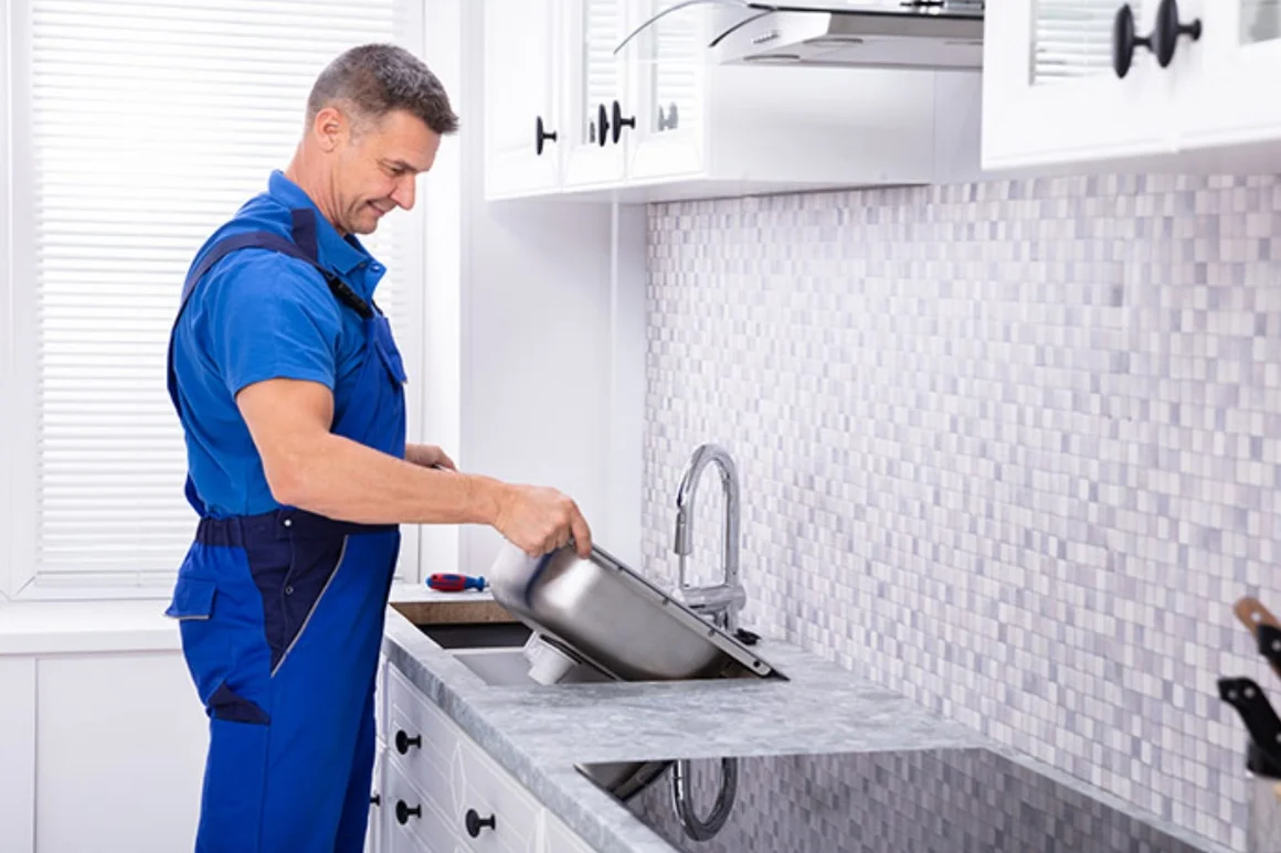 Person montiert Spüle in Küche.